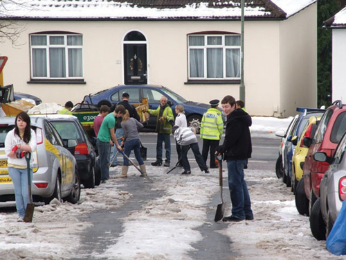 Photograph:   Caterham residents clearing the snow from their street last winter. 