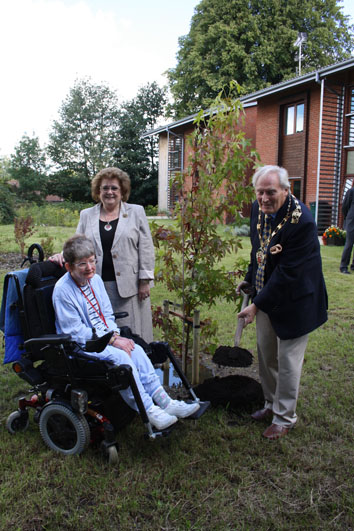 Cllr. Brian Perkins, his wife Sonia and Robinsfield Gardens tenant, Celia McCarthy with the newly-planted Acer Davidii tree.