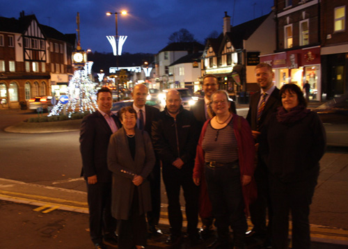 Members of Caterham Valley Parish Council and the Caterham Business Partnership in Caterham Valley, with the new lights in the background.