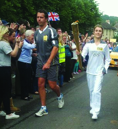 15 year old Amy Earl from Caterham carries the Olympic Torch through Godstone